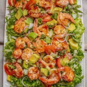 A close up of avocado shrimp salad on a large white plate.