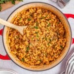 A large pot full of homemade hamburger helper ready to be served with a wooden spoon inserted.